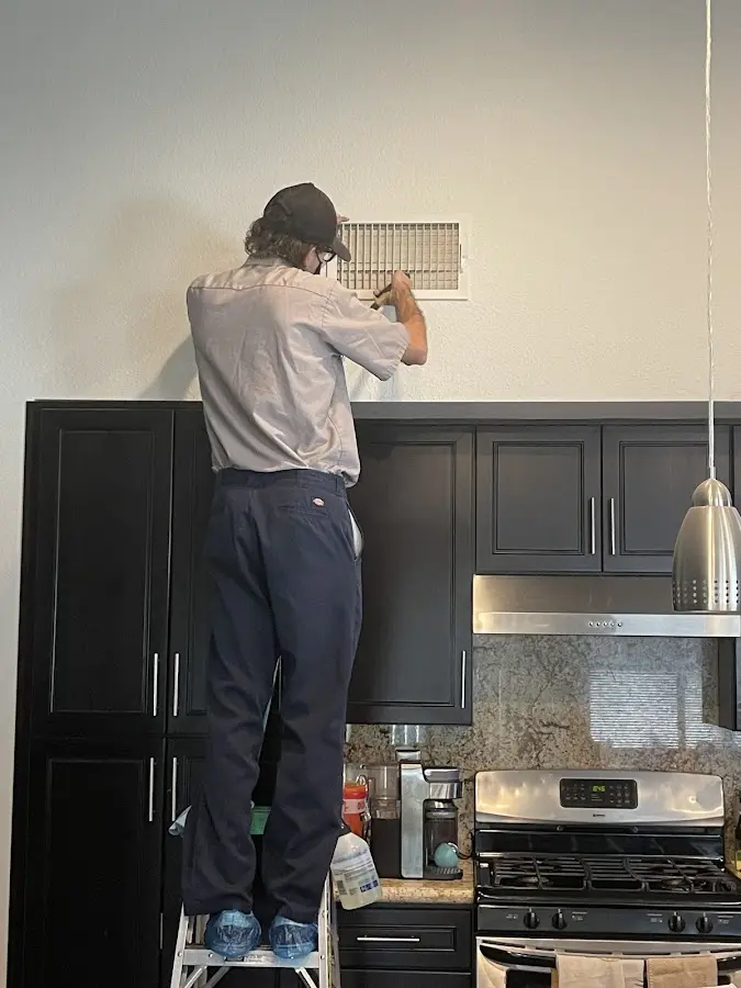 Technician inspecting an air vent during HVAC service in Discovery Bay